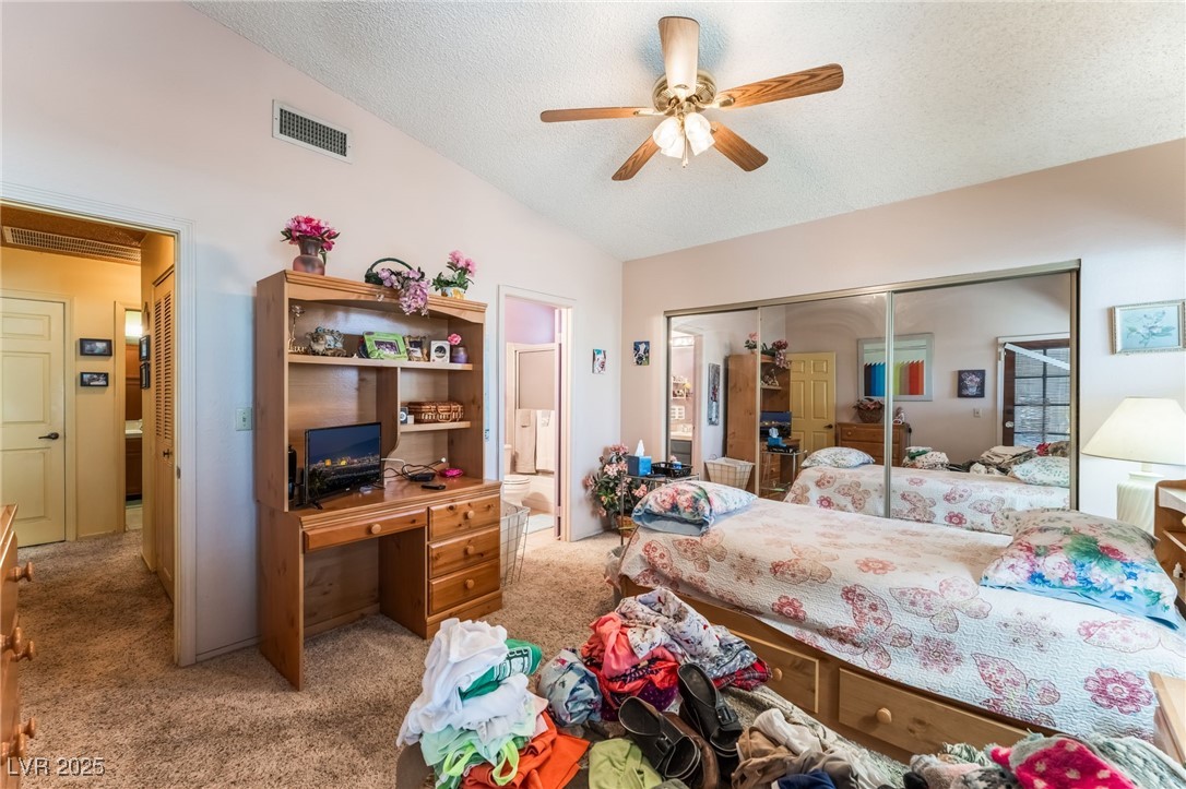 6513 Deadwood Road Las Vegas, NV 89108 - Photo 20 of 34 Carpeted bedroom featuring lofted ceiling, a textured ceiling, a closet, an office area, and ceiling fan