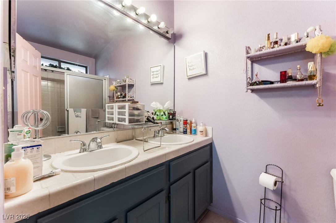 6513 Deadwood Road Las Vegas, NV 89108 - Photo 24 of 34 Full bath featuring double vanity and baseboards