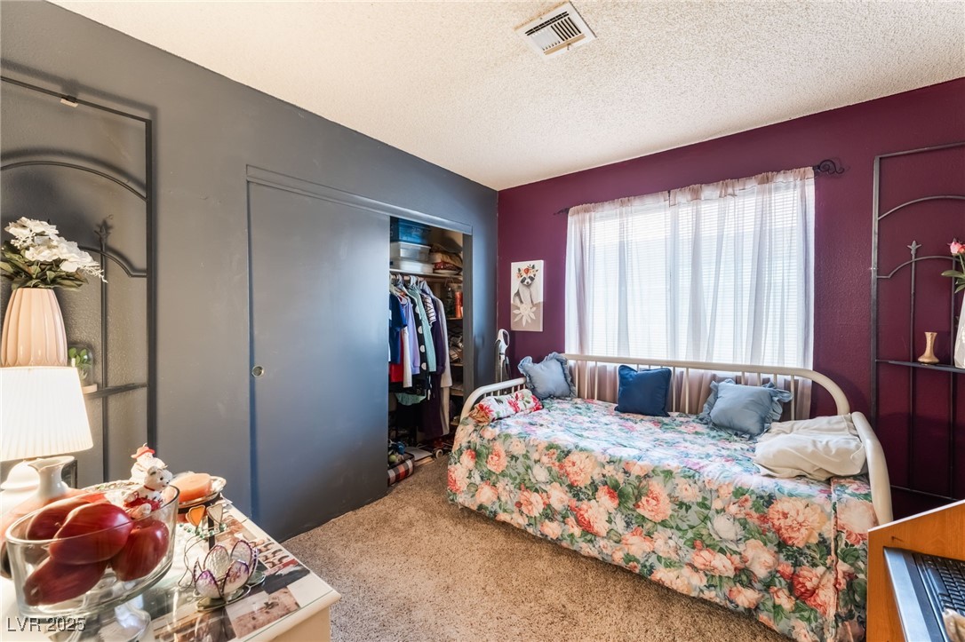 6513 Deadwood Road Las Vegas, NV 89108 - Photo 26 of 34 Carpeted bedroom featuring a textured ceiling and a closet