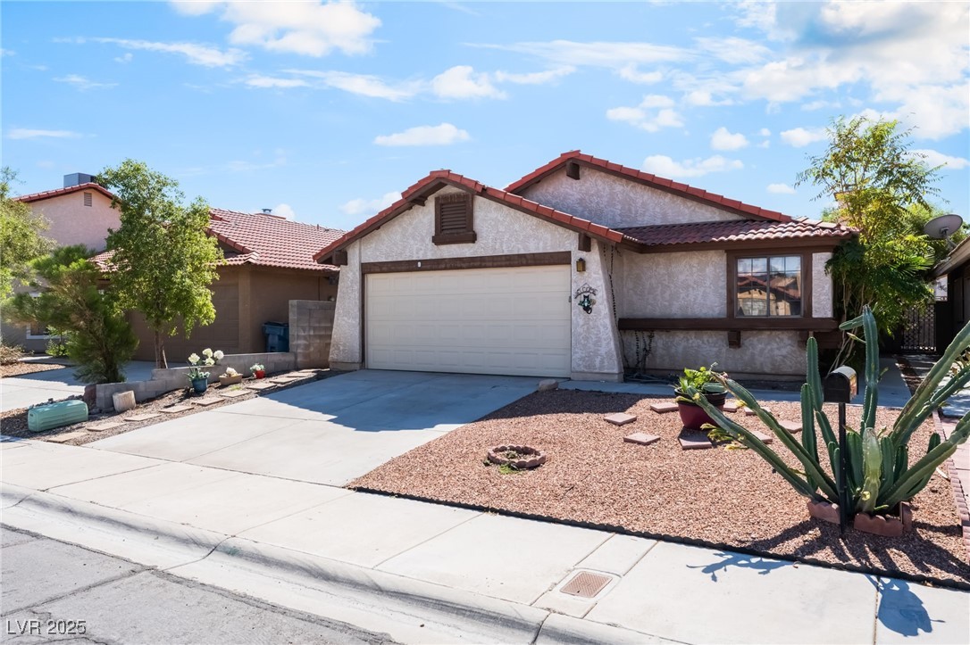 6513 Deadwood Road Las Vegas, NV 89108 - Photo 4 of 34 View of front of home with driveway, stucco siding, a garage, and a tile roof