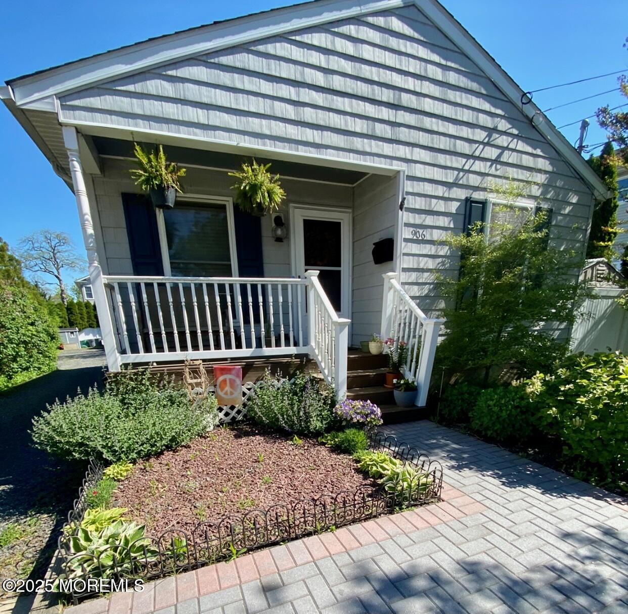 906 16th Avenue, Unit FRONT Belmar, NJ 07719 - Photo 1 of 10 a view of a house with potted plants and a bench