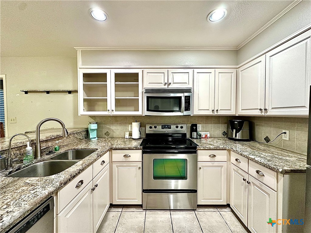 120 Andover Street Victoria, TX 77904 - Photo 18 of 40 a kitchen with stainless steel appliances granite countertop a sink a stove a microwave and cabinets