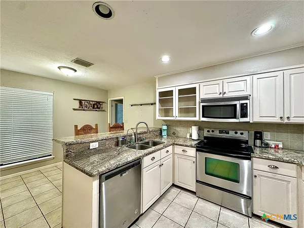 a kitchen with stainless steel appliances a stove sink microwave and cabinets
