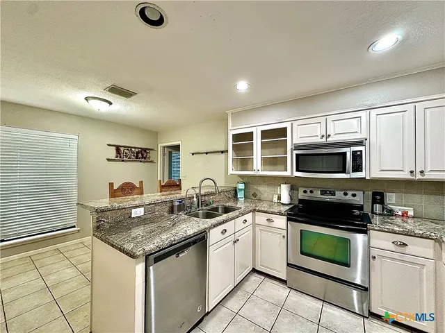 a kitchen with stainless steel appliances a stove sink microwave and cabinets