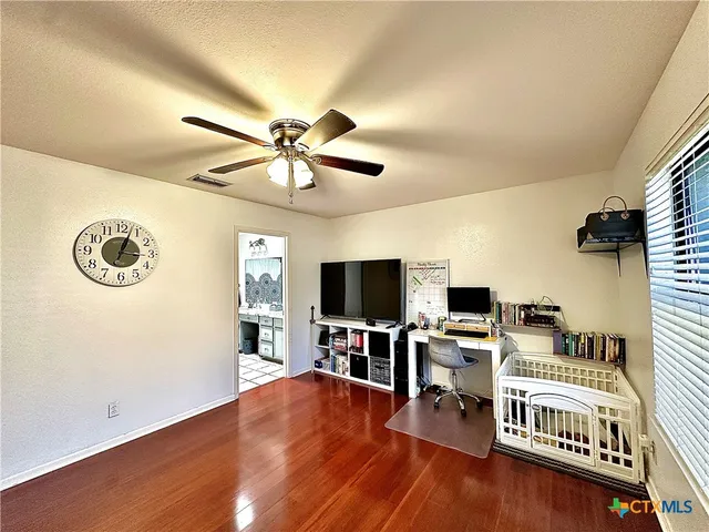a view of a livingroom with workspace and a window