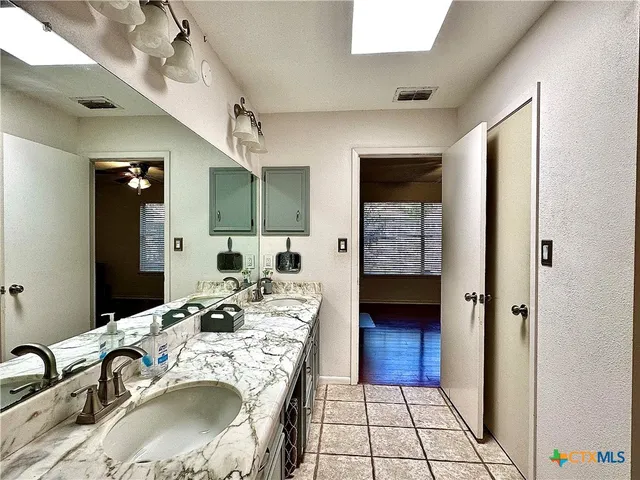 a bathroom with a double vanity sink a mirror and a shower