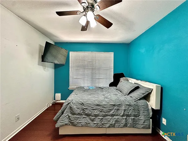 a bedroom with a bed and a ceiling fan