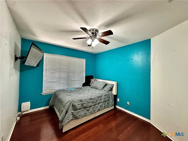 a bedroom with a bed and a ceiling fan