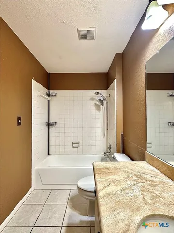 a bathroom with a tub shower and sink