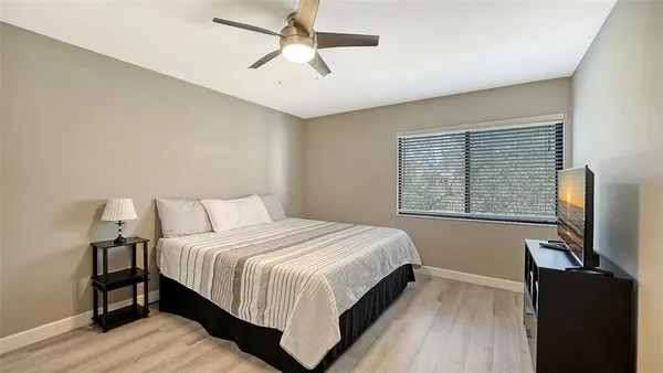 a bedroom with two beds and a ceiling fan