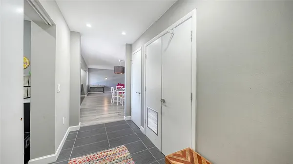 a kitchen with stainless steel appliances kitchen island granite countertop a stove a refrigerator a microwave oven a dining table and chairs with wooden floor