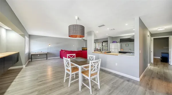 a view of a dining room with furniture a chandelier and wooden floor