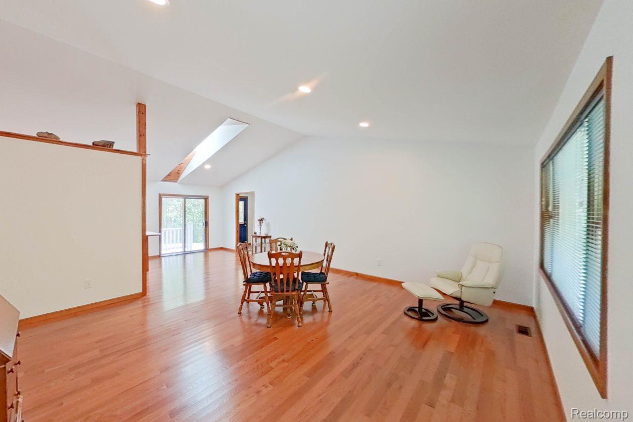 10201 Washburn Road Goodrich, MI 48438 - Photo 36 of 85 Spacious room featuring vaulted ceilings, a prominent skylight, wood-finish flooring, recessed lighting, and a large window with blinds