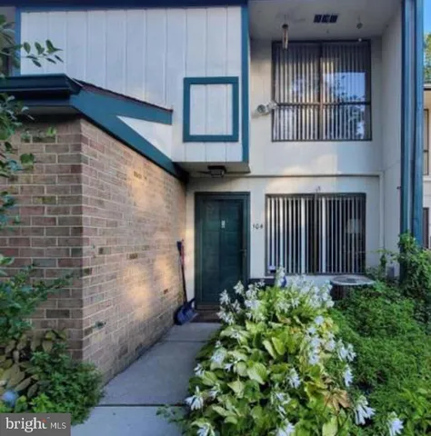 a view of a house with large windows and flower plants