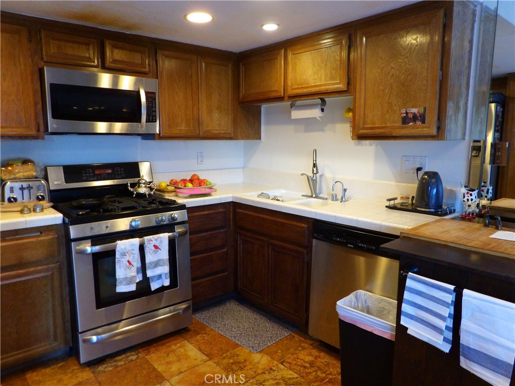 19140 Lahey Street, Unit 4 Porter Ranch, CA 91326 - Photo 6 of 37 a kitchen with stainless steel appliances a stove a sink and a microwave