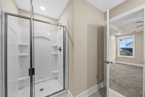 a bathroom with a glass shower door and a glass door