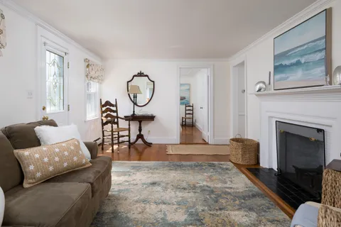 a living room with furniture a fireplace and a large window