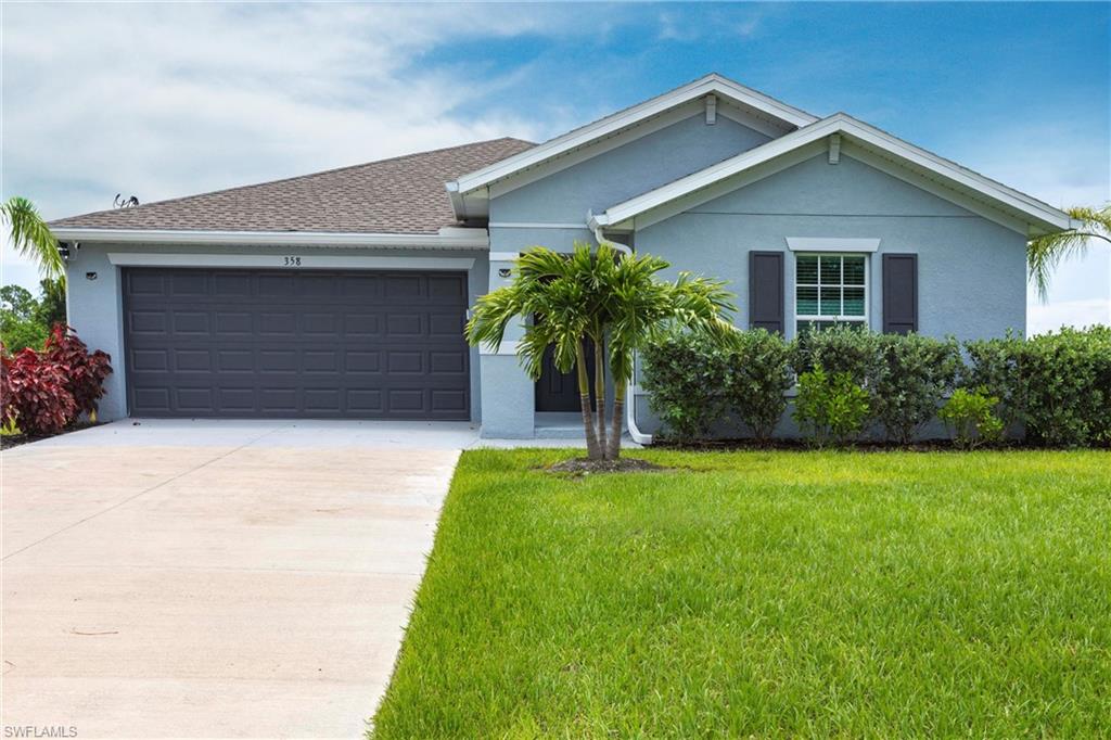 358 Pembroke Street Lehigh Acres, FL 33974 - Photo 1 of 45 a front view of house with yard and garage