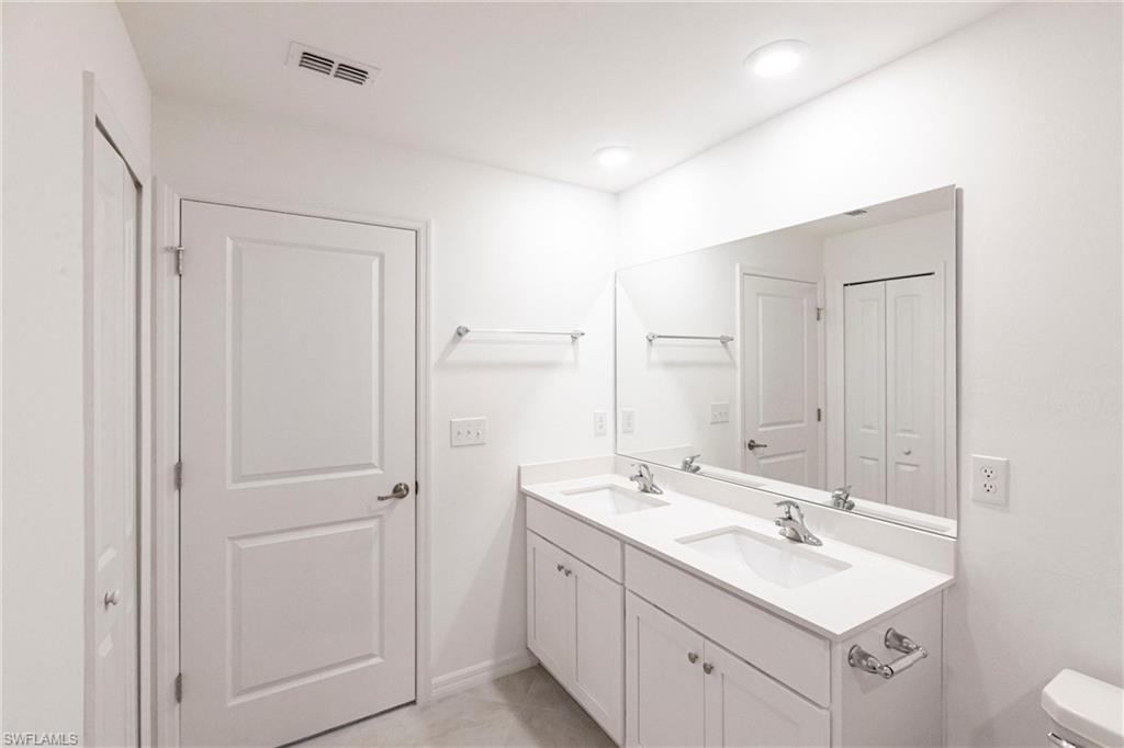 358 Pembroke Street Lehigh Acres, FL 33974 - Photo 29 of 45 a bathroom with 2 sink mirror and toilet