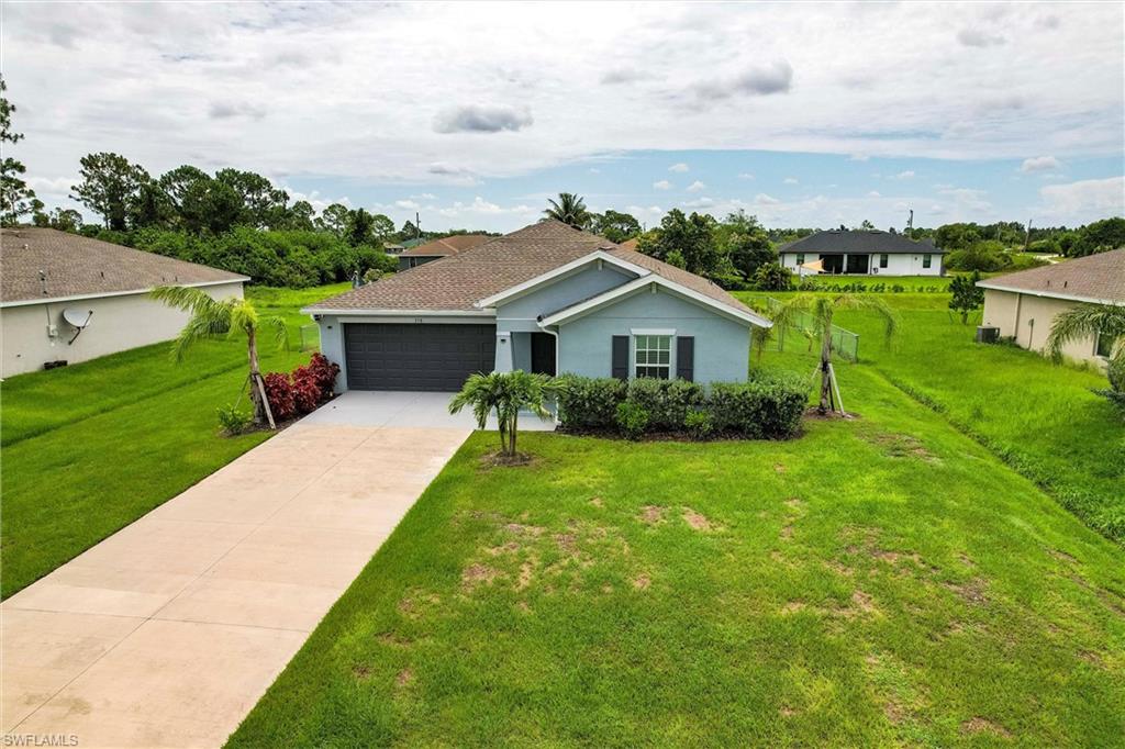 358 Pembroke Street Lehigh Acres, FL 33974 - Photo 39 of 45 a house with green field in front of it