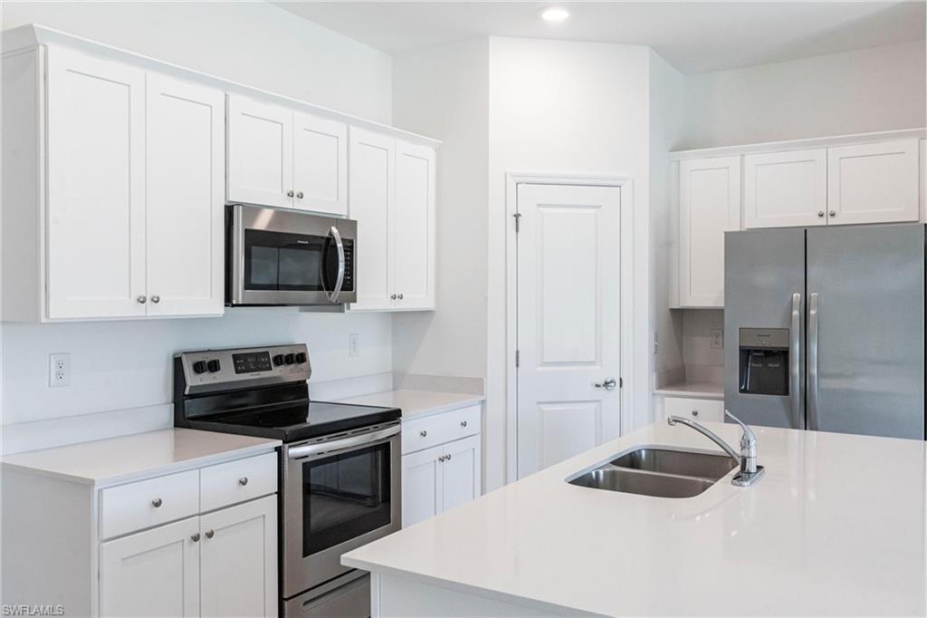 358 Pembroke Street Lehigh Acres, FL 33974 - Photo 9 of 45 a kitchen with a sink stove and microwave