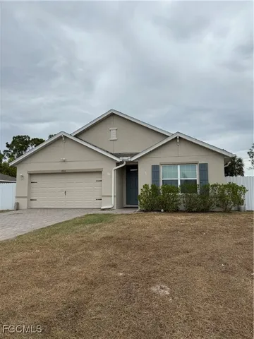 a front view of house with yard and garage