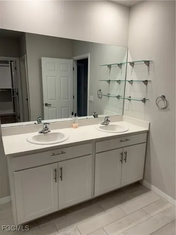 a bathroom with a double vanity sink and a mirror
