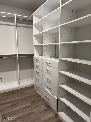 a view of walk in closet with empty racks