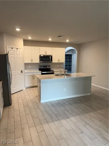 a large kitchen with stainless steel appliances granite countertop a stove a sink and a refrigerator