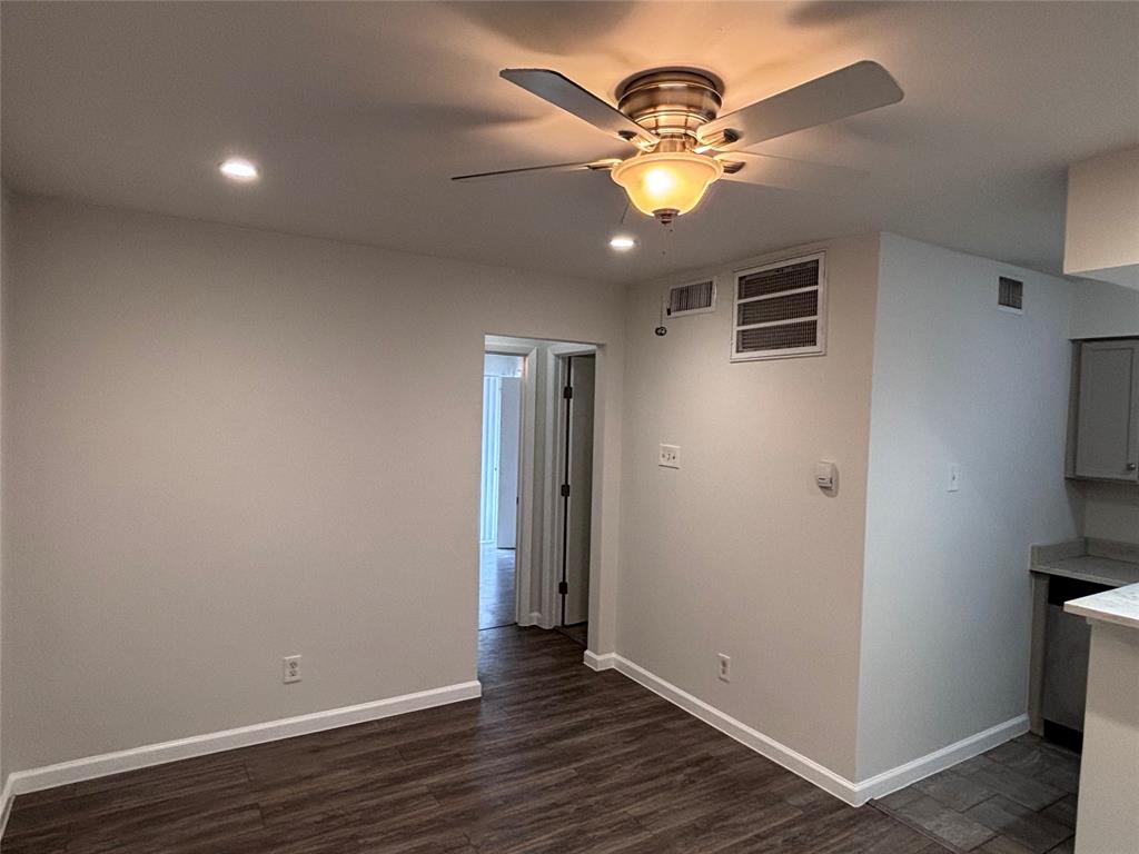 4300 Congress Avenue, Unit 216 Dallas, TX 75219 - Photo 2 of 13 an empty room with wooden floor fan and windows