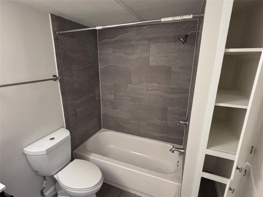 4300 Congress Avenue, Unit 216 Dallas, TX 75219 - Photo 7 of 13 a bathroom with a toilet and a bathtub