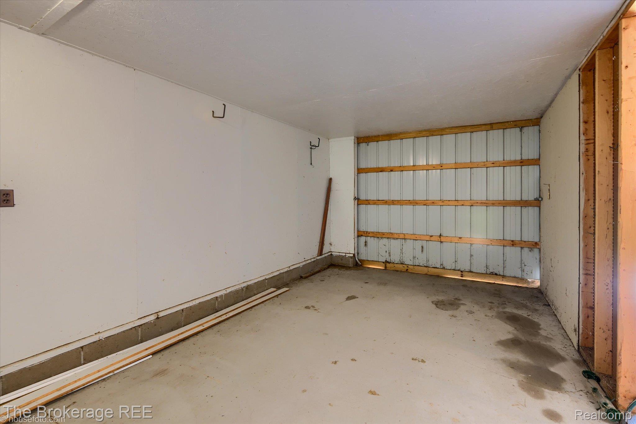 5495 East Coldwater Road Flint, MI 48506 - Photo 44 of 44 Unfinished utility space featuring exposed wood framing, white walls, and a corrugated metal wall
