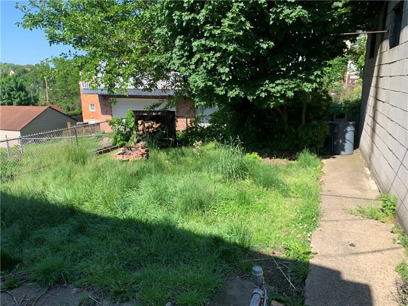 134 Rinne Street Pittsburgh, PA 15210 - Photo 23 of 23 a view of backyard with potted plants and a large tree