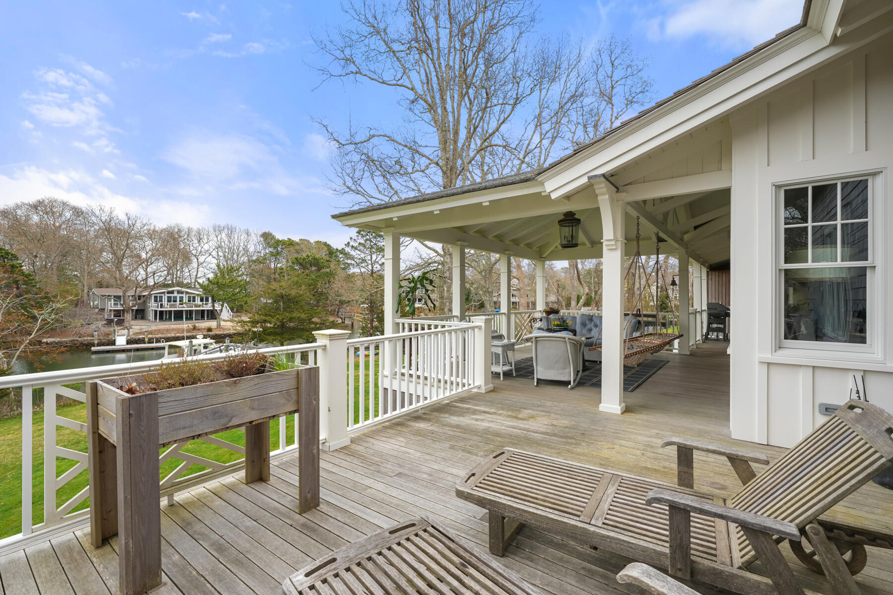 112 Wading Place Road Mashpee, MA 02649 - Photo 13 of 58 a view of a patio with table and chairs with wooden floor and fence