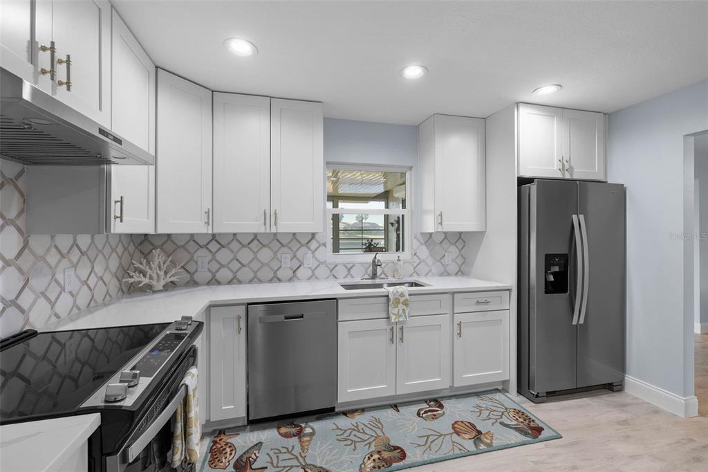 4151 Camelia Drive Hernando Beach, FL 34607 - Photo 13 of 37 a kitchen with a sink a refrigerator and cabinets