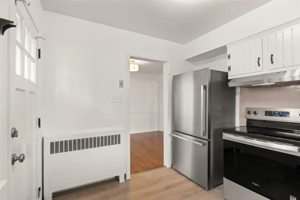 a kitchen with stainless steel appliances granite countertop a refrigerator a stove and a sink with wooden floor