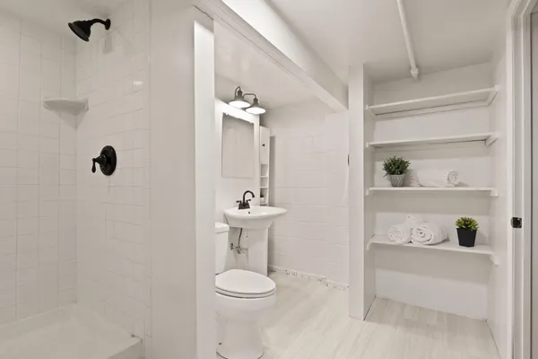 a bathroom with a sink a toilet and shower