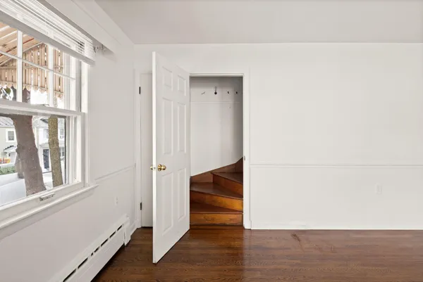 a view of hallway with stairs and wooden floor
