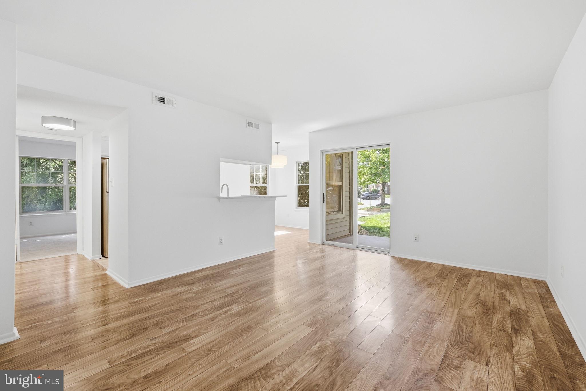 1703 Ascot Way, Unit D Reston, VA 20190 - Photo 8 of 21 a view of an empty room with wooden floor and a window