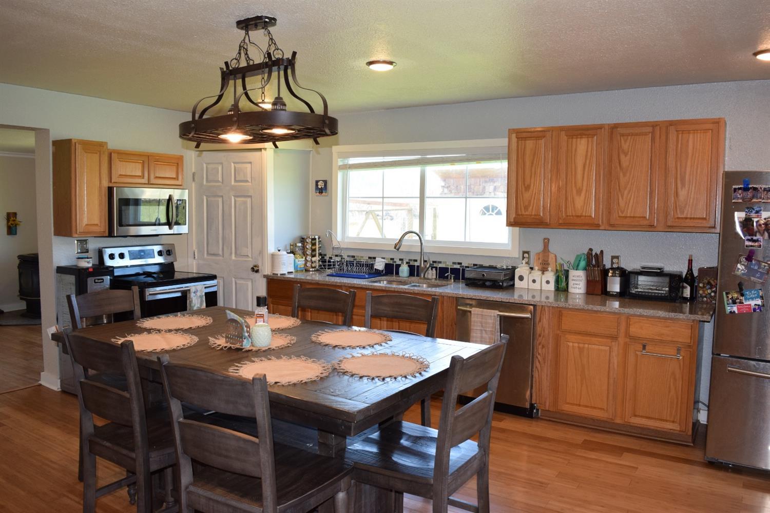 210 Red Road Sutherlin, OR 97479 - Photo 10 of 24 a kitchen with a dining table chairs stainless steel appliances and cabinets