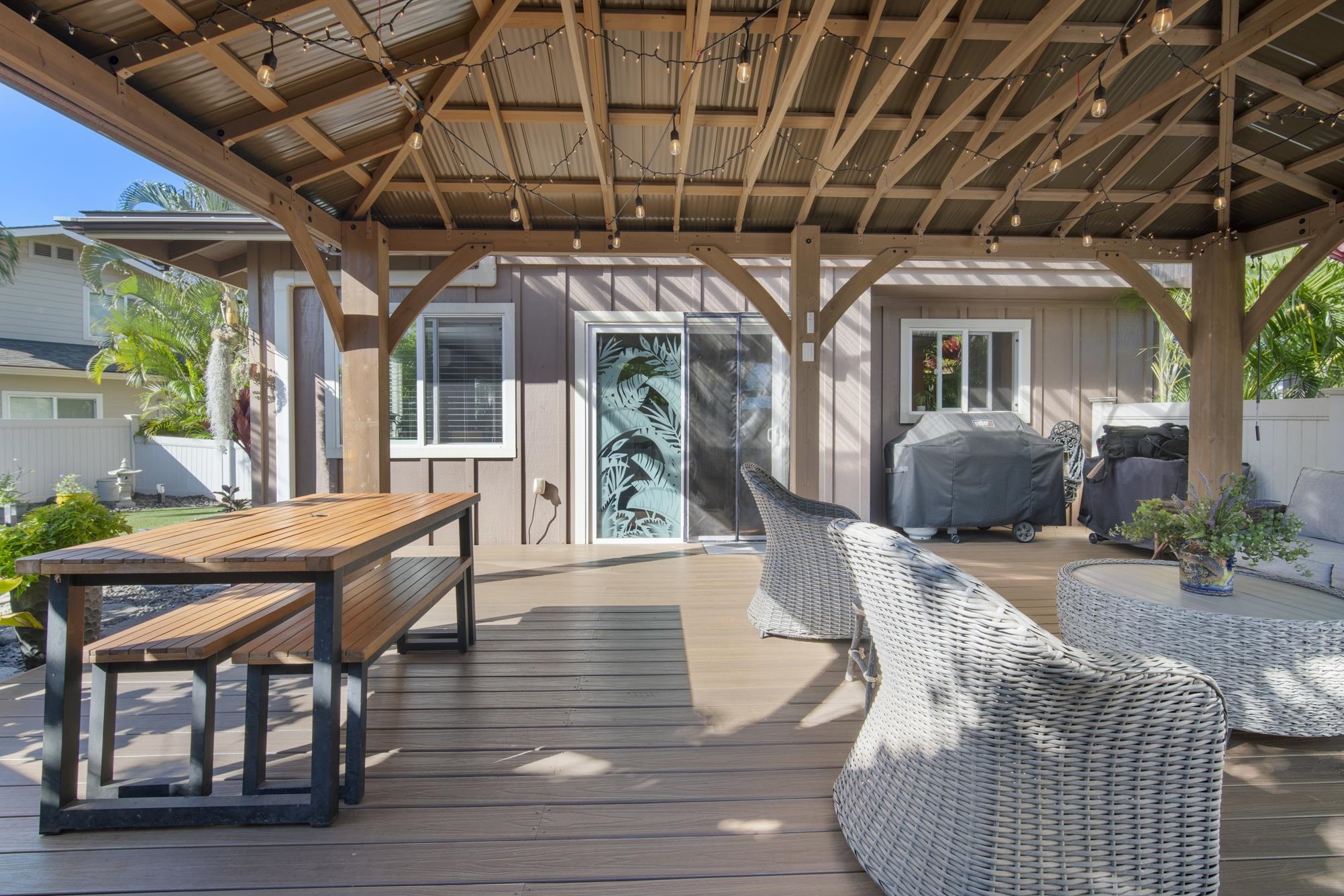 223 Lau Oliwa Loop, Unit 38 Wailuku, HI 96793 - Photo 33 of 50 a view of a patio with table and chairs potted plants with wooden floor and floor to ceiling window