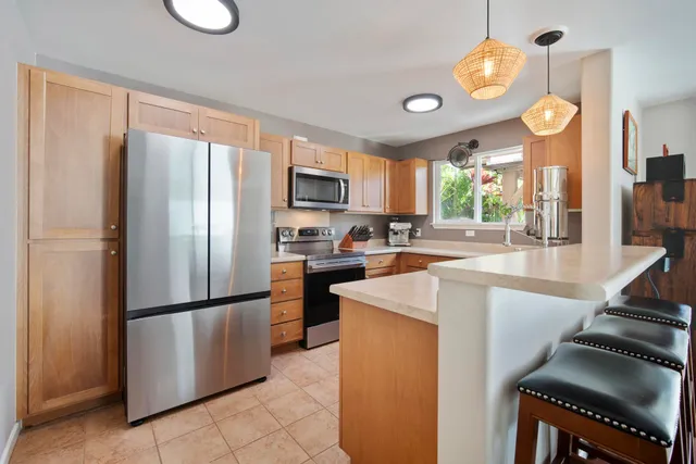a kitchen with stainless steel appliances granite countertop a refrigerator a stove a sink and a refrigerator