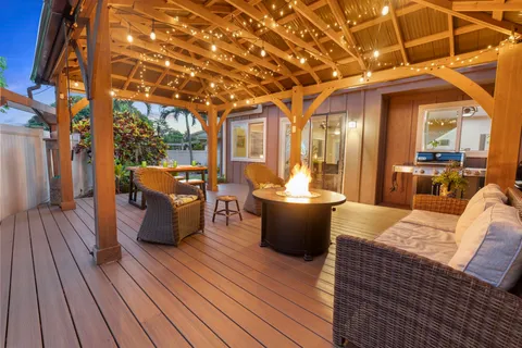a view of a patio with couches dining table and chairs with wooden floor