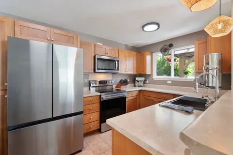 a kitchen with stainless steel appliances granite countertop a refrigerator a stove top oven a sink and dishwasher