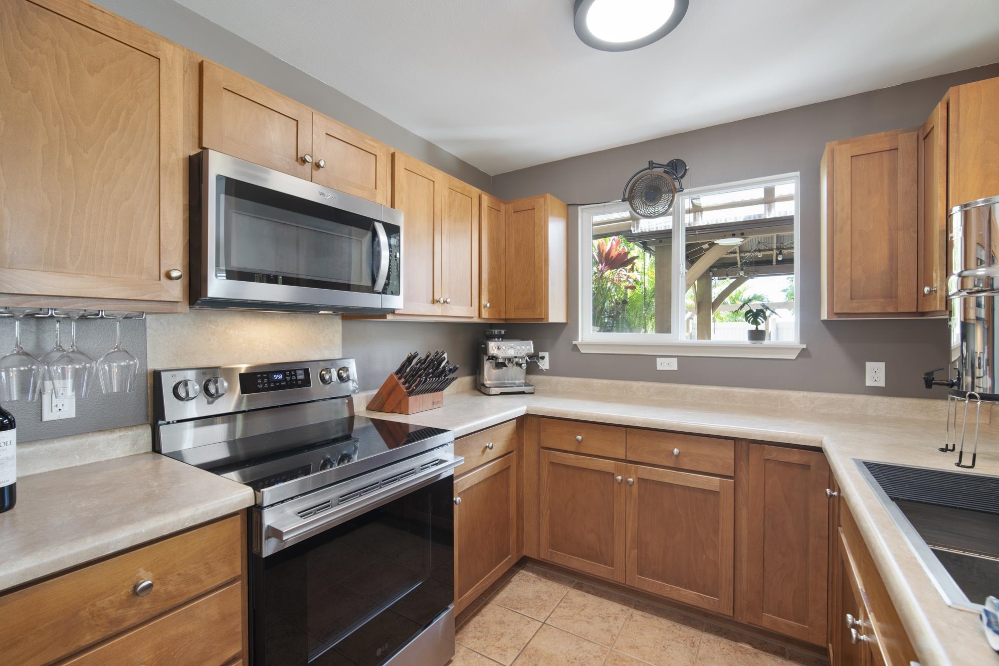 223 Lau Oliwa Loop, Unit 38 Wailuku, HI 96793 - Photo 9 of 50 a kitchen with stainless steel appliances granite countertop a sink a stove a microwave cabinets and a window