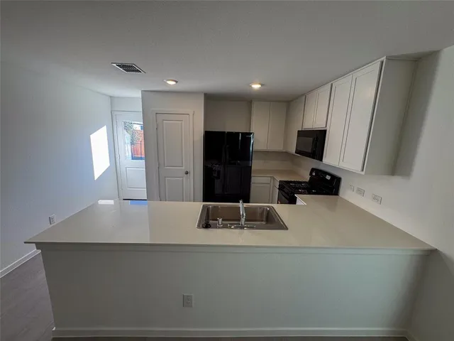 a kitchen with kitchen island a sink stove and refrigerator