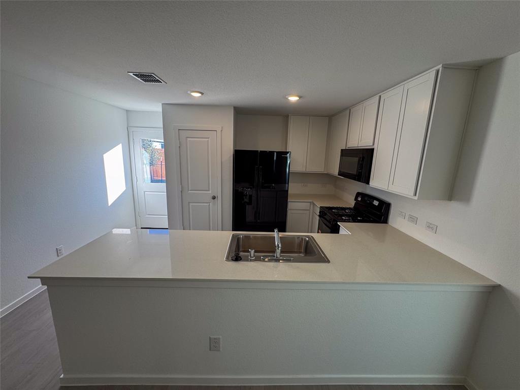 3915 Selawik Street Sherman, TX 75090 - Photo 6 of 19 a kitchen with kitchen island a sink stove and refrigerator