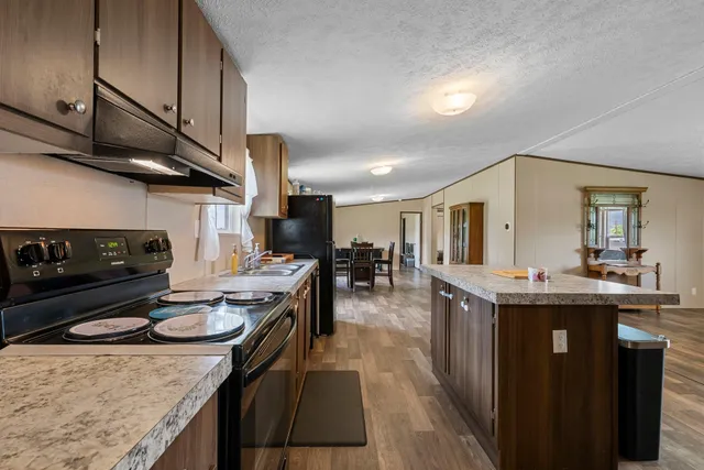 a kitchen with stainless steel appliances granite countertop a sink stove and cabinets