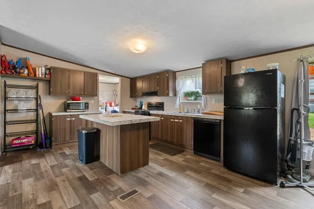 a kitchen with stainless steel appliances granite countertop a refrigerator stove and sink