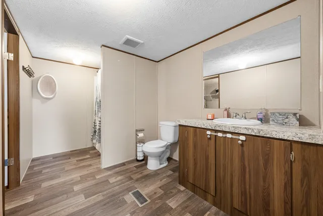 a bathroom with a granite countertop sink toilet and shower